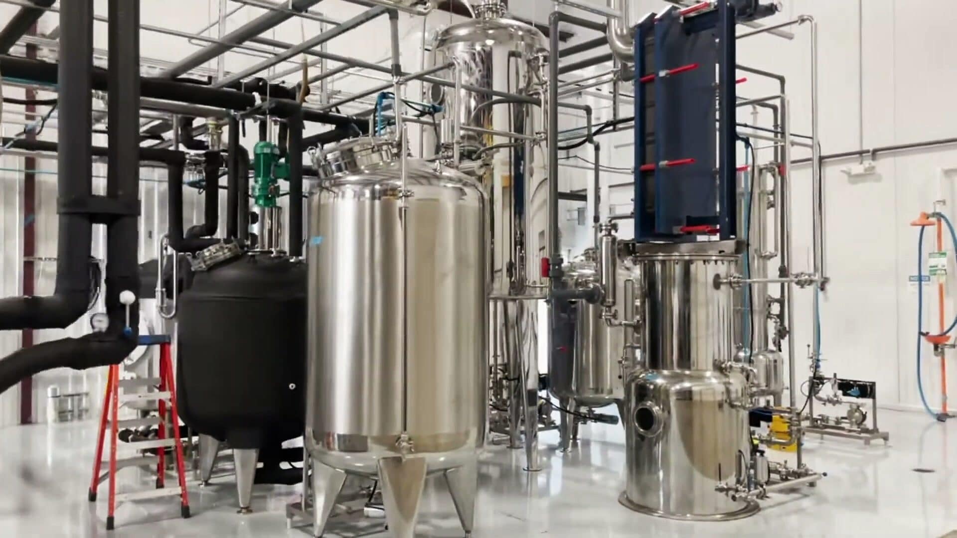Evaporator, tanks and plate heat exchanger beside a red step ladder