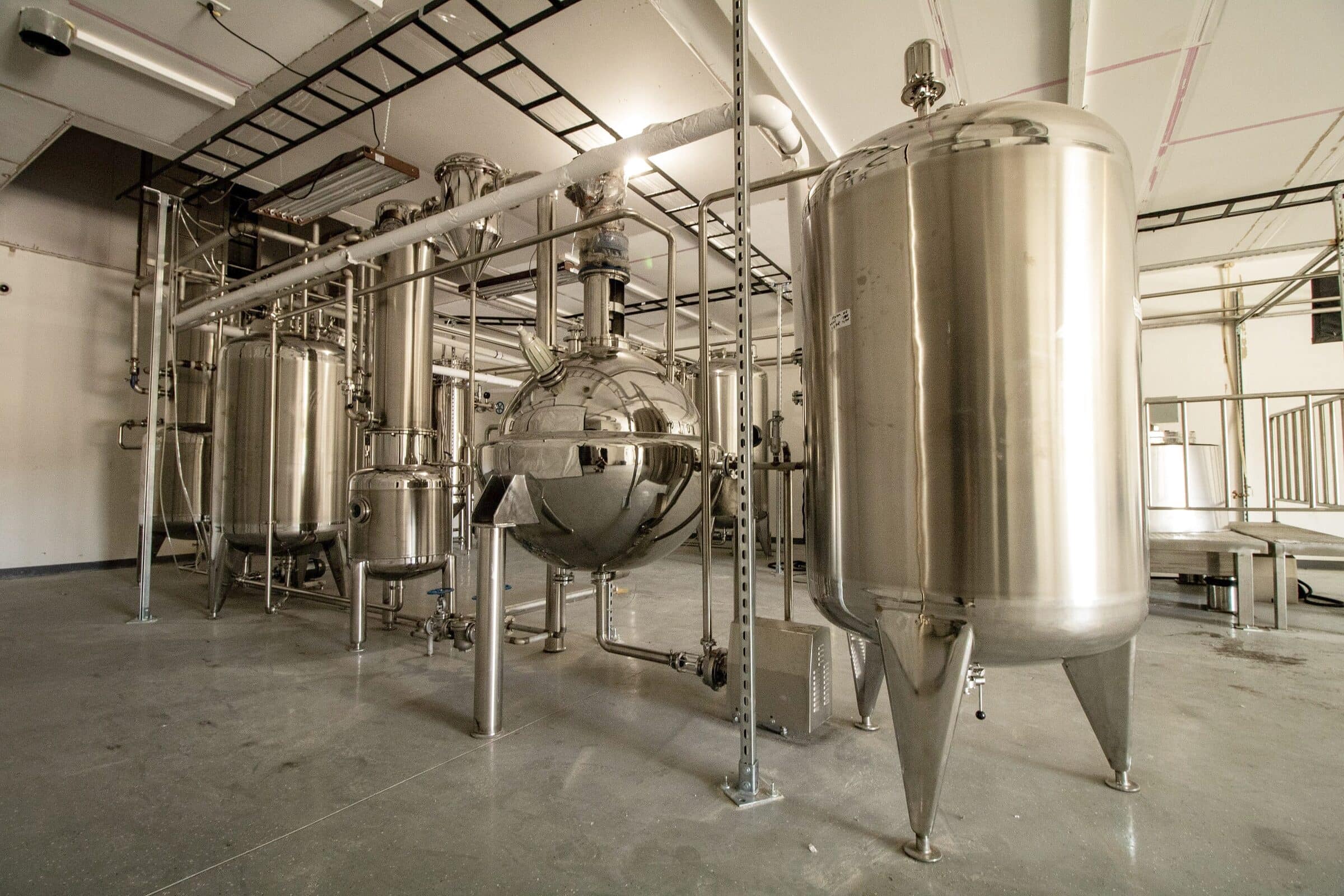 A spherical stainless vessel between tall conical tanks