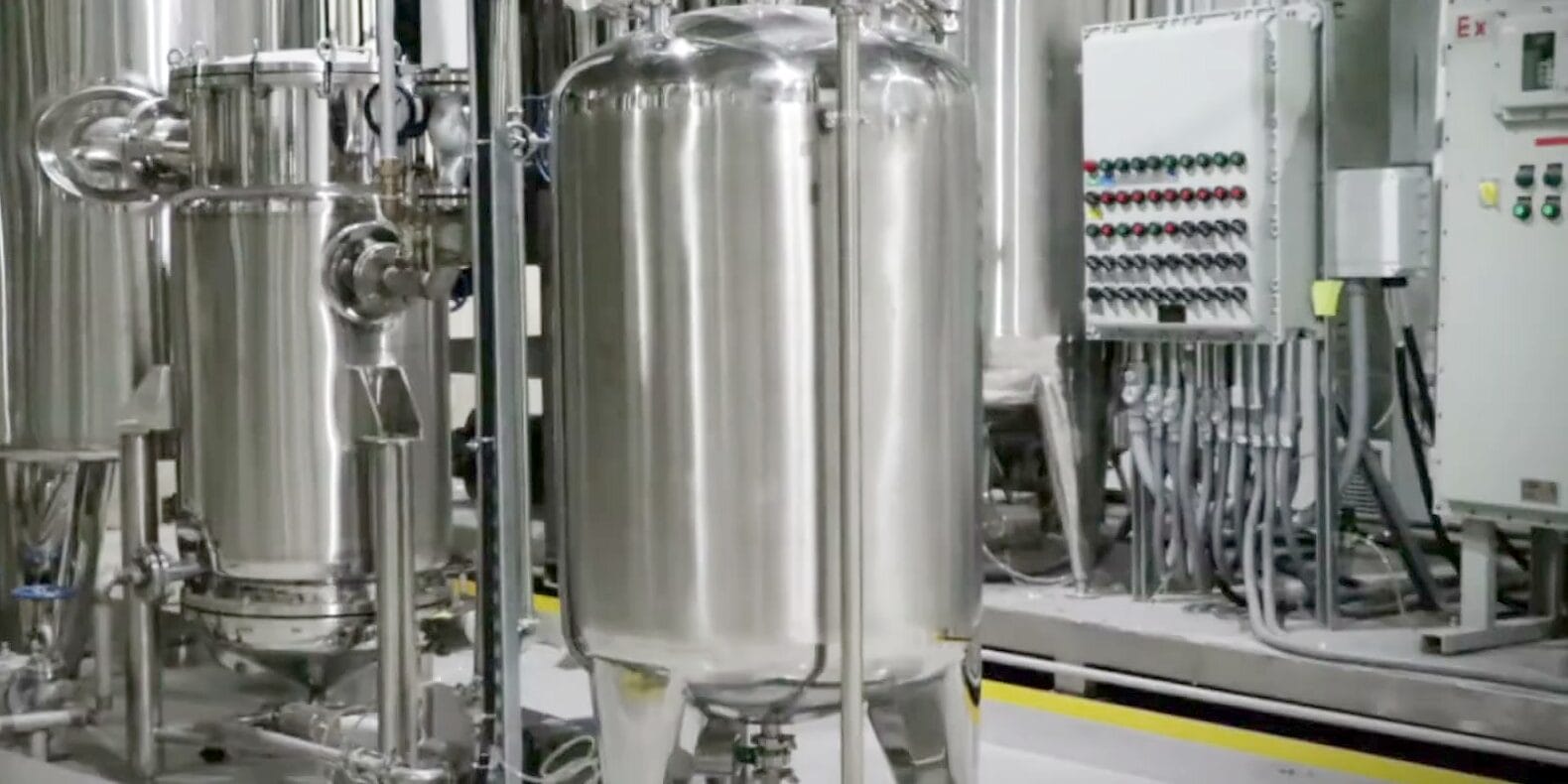 Stainless tanks and an explosion-proof control panel on a yellow-edged floor