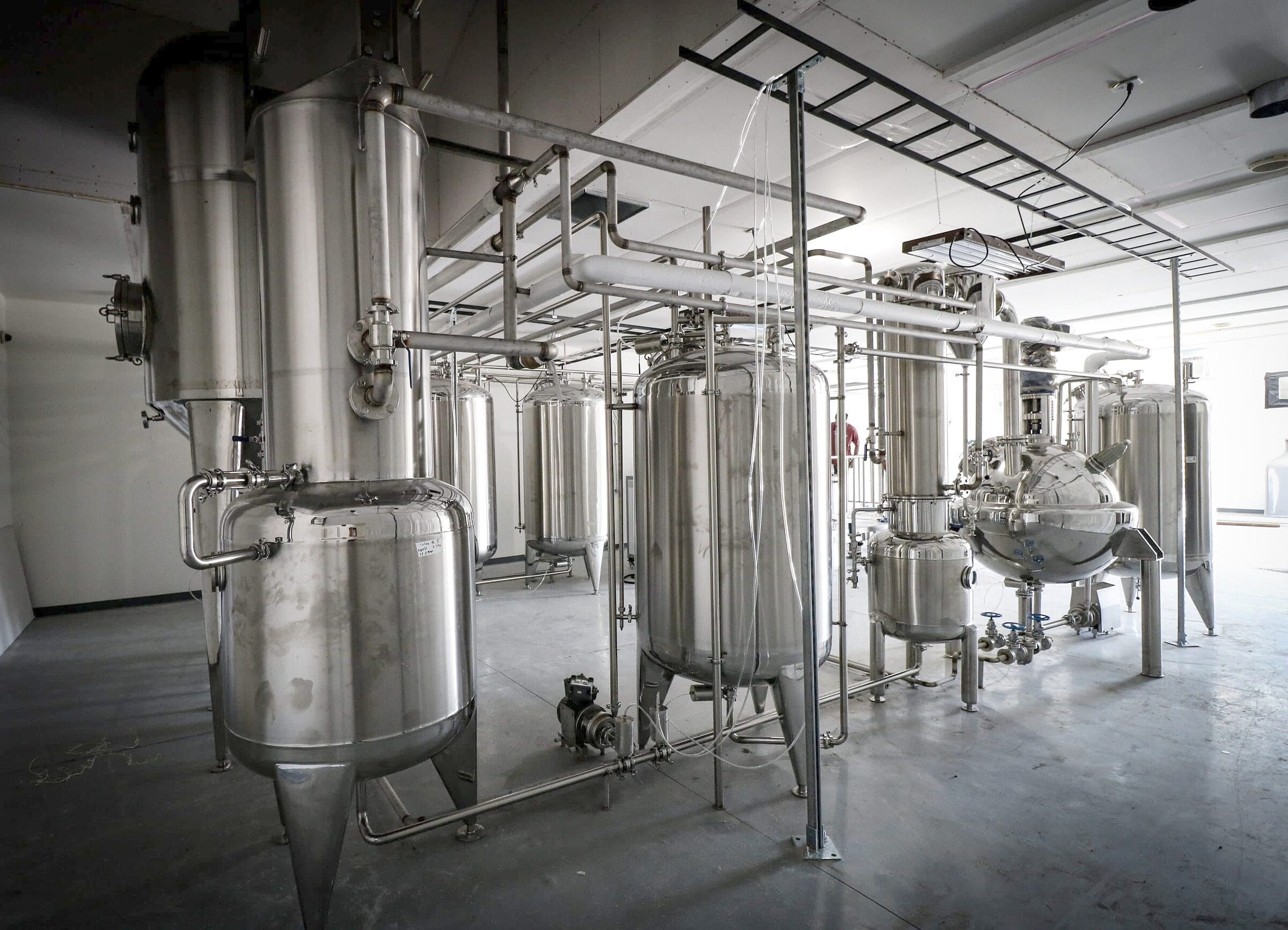 Stainless tanks, evaporators and a spherical vessel on a shop floor