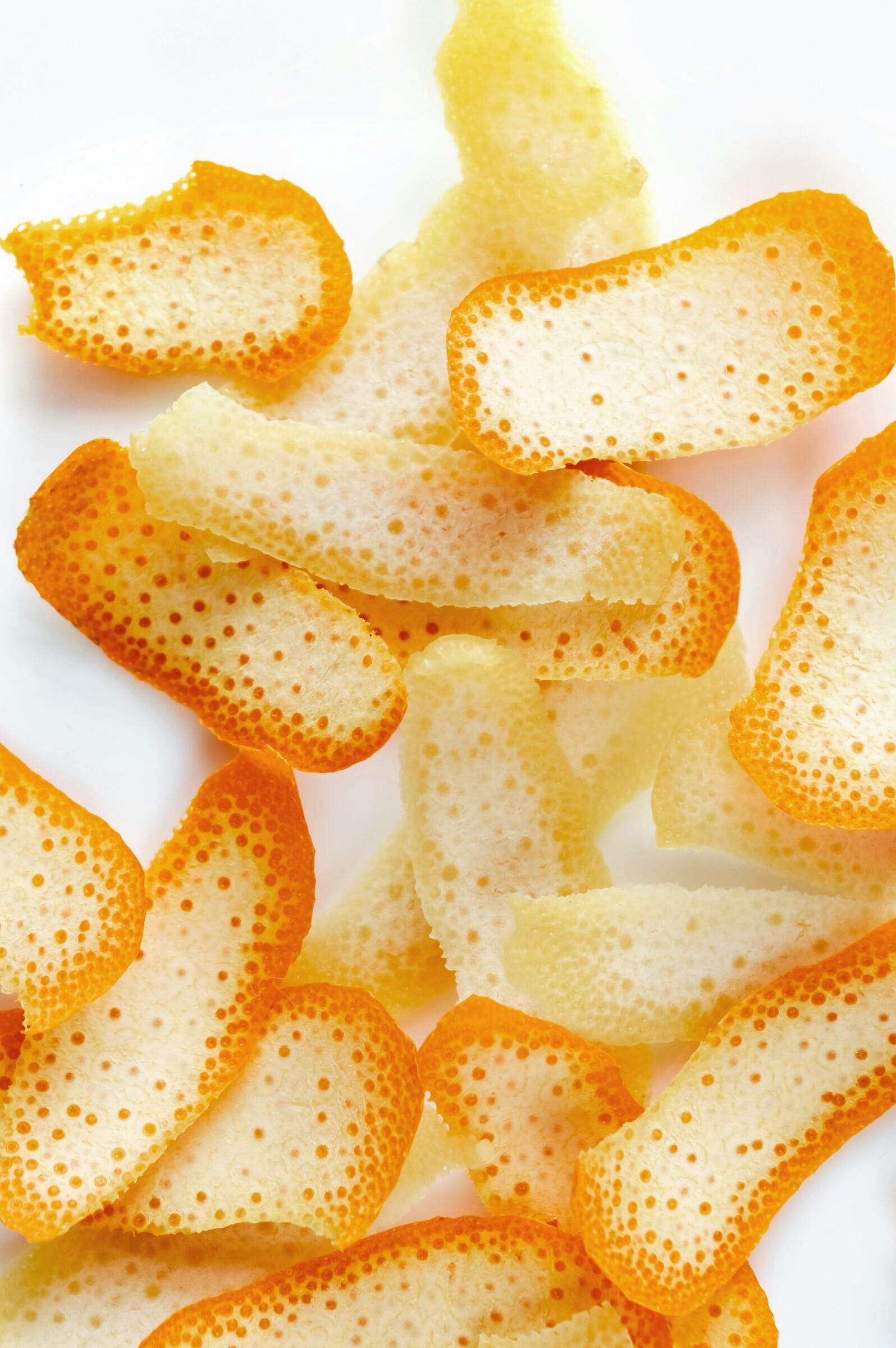 Curls of fresh orange peel on white