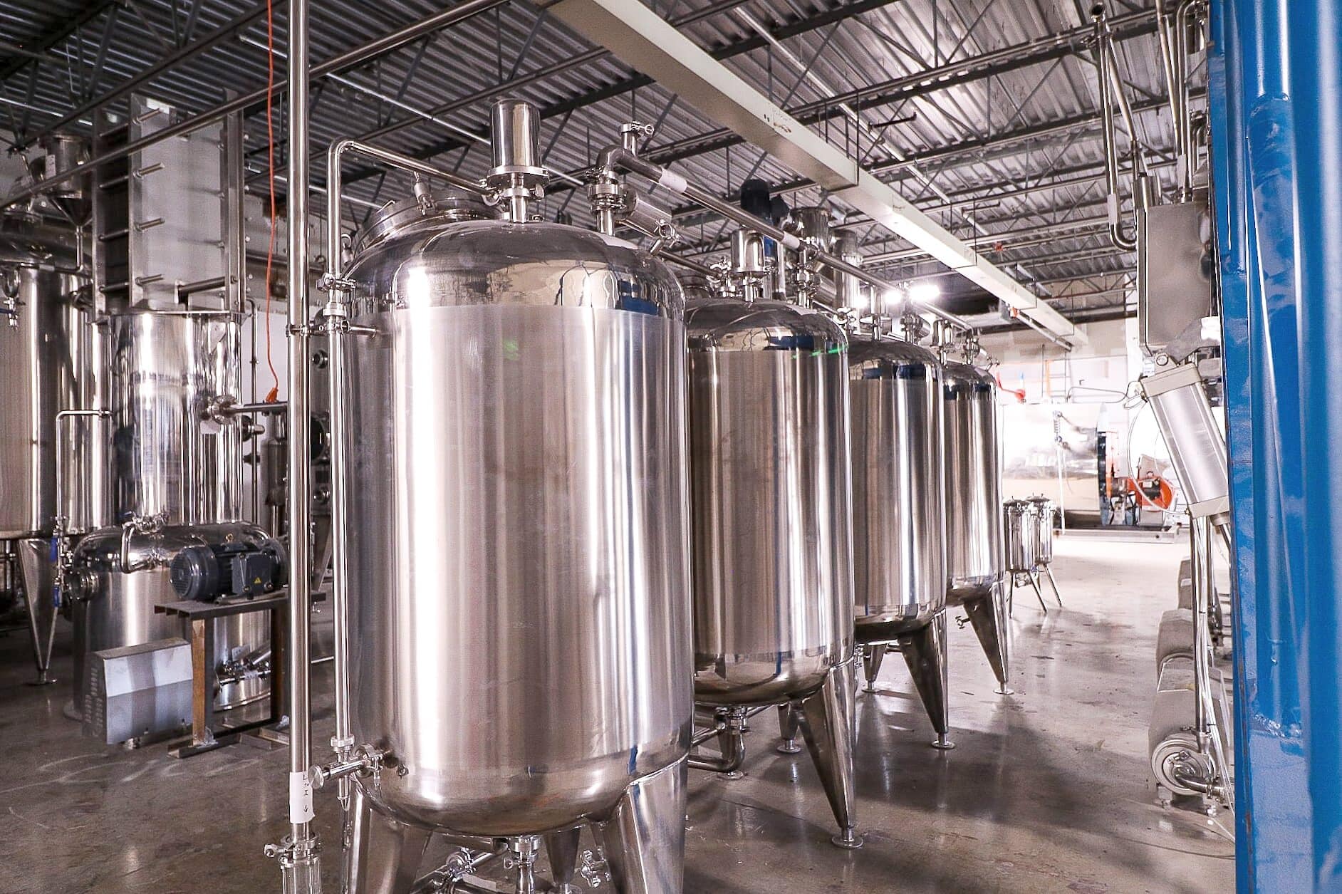 Tall stainless process tanks in a production hall